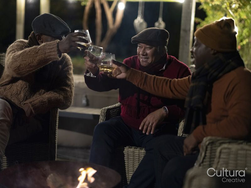 Male friends relaxing on patio and raising toast