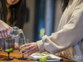 Women preparing alcoholic cocktails in kitchen