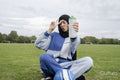 Portrait of woman in hijab sitting in soccer field with water bottle