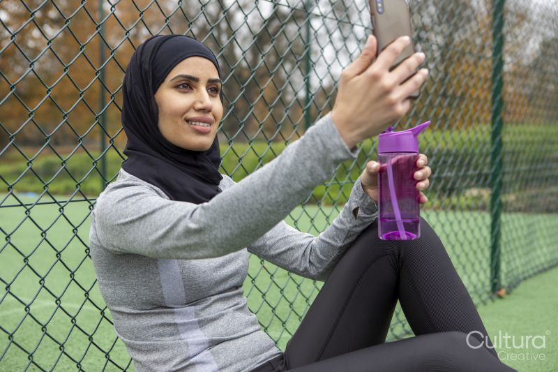 Woman in hijab taking selfie on basketball court