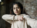 Young brunette female aiming during archery training