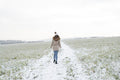 Rear view of woman walking in snowy field