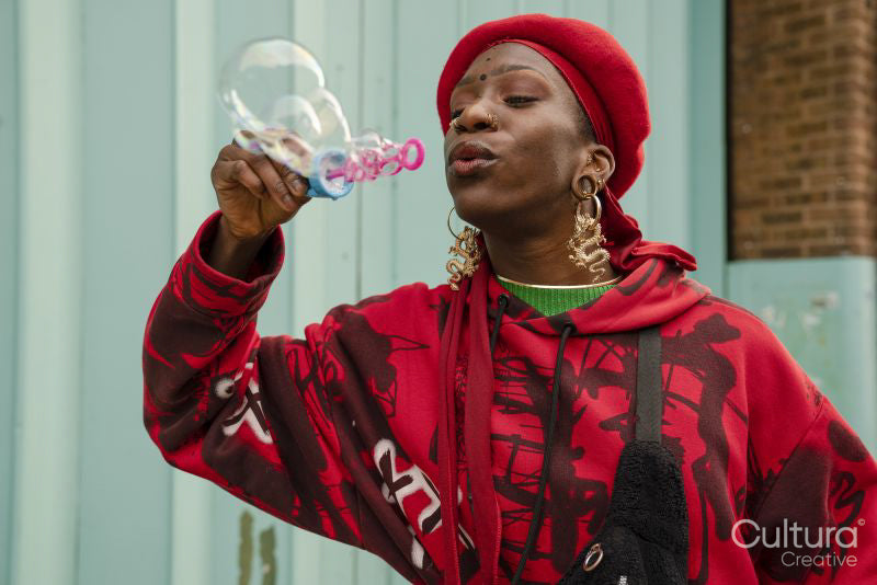 Young woman in red blowing bubbles