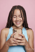 Studio shot of smiling girl with braids looking at smart phone