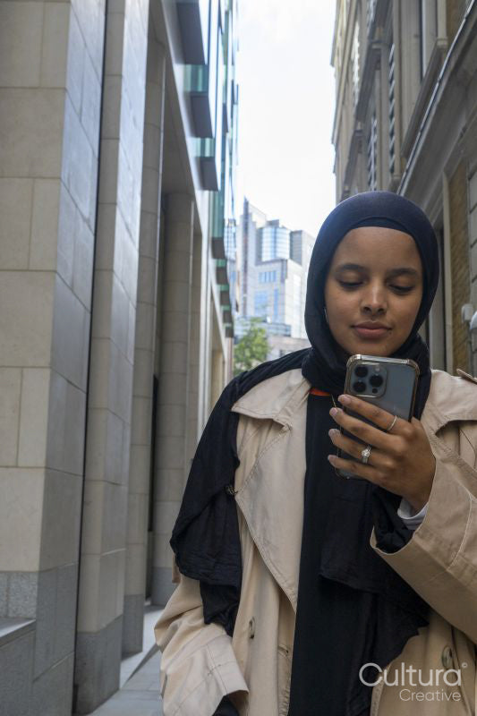 Young woman using phone in street