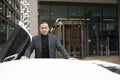 Portrait of mature man leaning against luxury car