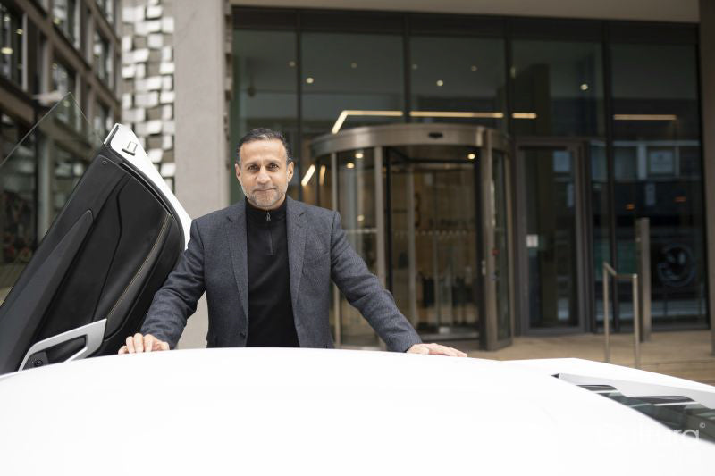 Portrait of mature man leaning against luxury car