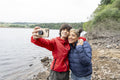Mother and son taking selfie by lake on hike