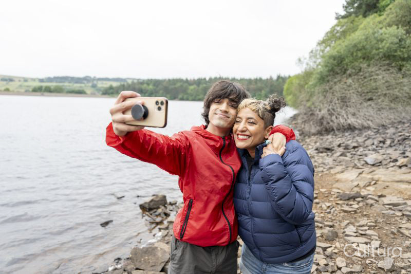 Mother and son taking selfie by lake on hike