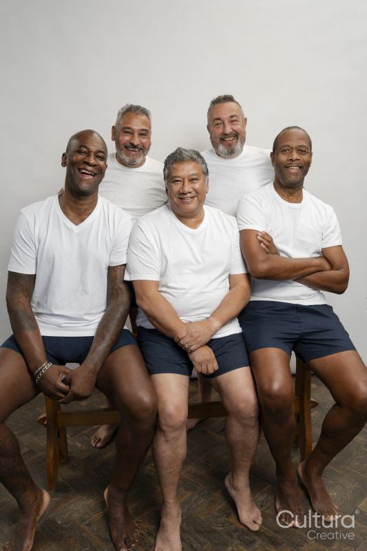 Group portrait of smiling senior men in white t-shirts against gray background