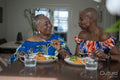 Smiling senior woman with adult daughter eating dinner at table