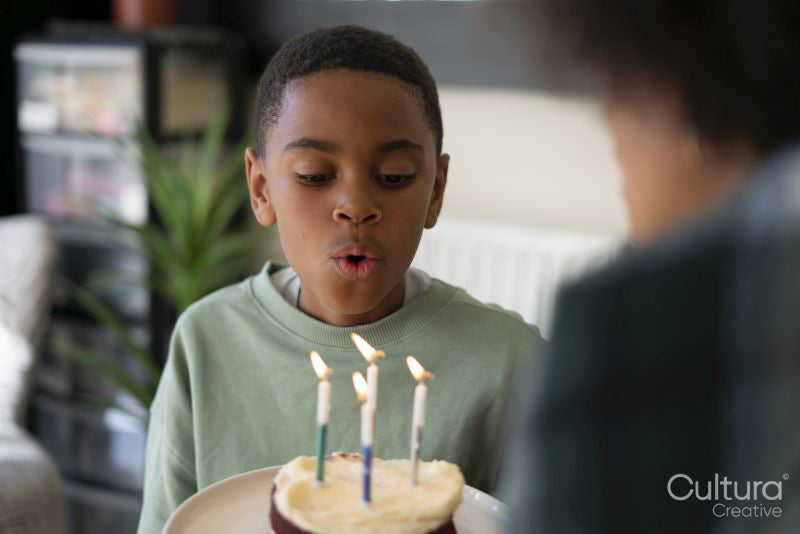 Boy blowing candles on birthday cake