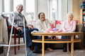 Cheerful senior people relaxing in common room at nursing home