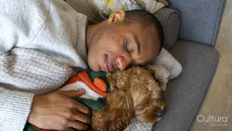 Man and dog sleeping on sofa