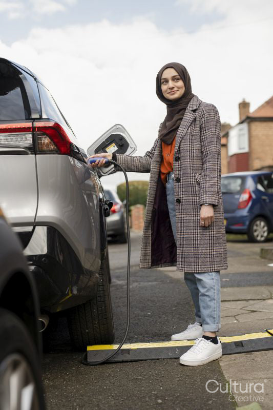 Woman wearing hijab charging electric car