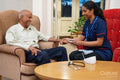 Nursing assistant using pulse oximeter on senior man at nursing home
