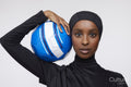 Studio portrait of young woman in hijab holding soccer ball