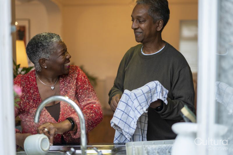 Senior couple washing dishes at home