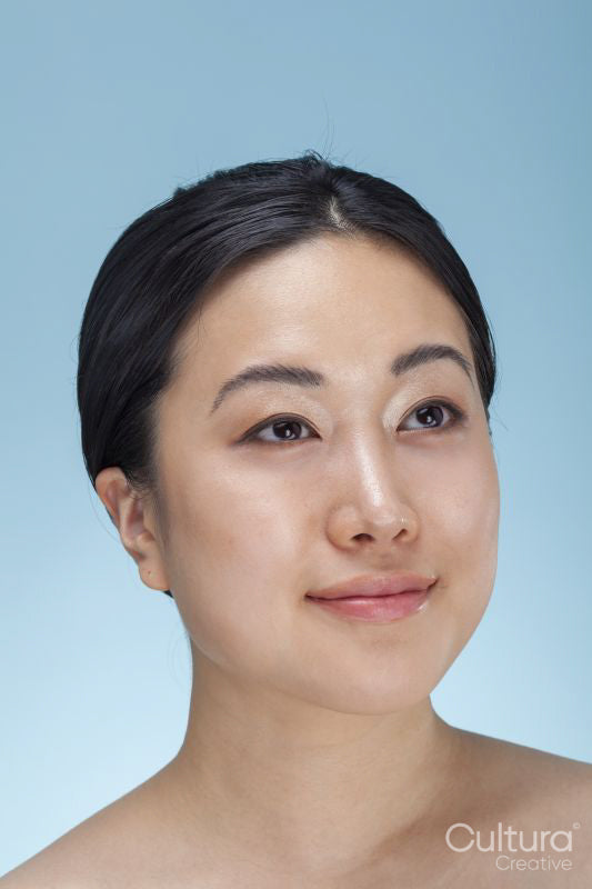 Studio portrait of smiling woman against blue background