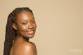 Studio portrait of smiling shirtless woman with braided hair