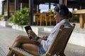 Woman using laptop with headphones at poolside