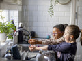 Girls washing hands in kitchen sink