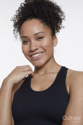 Studio portrait of smiling athletic woman in black top