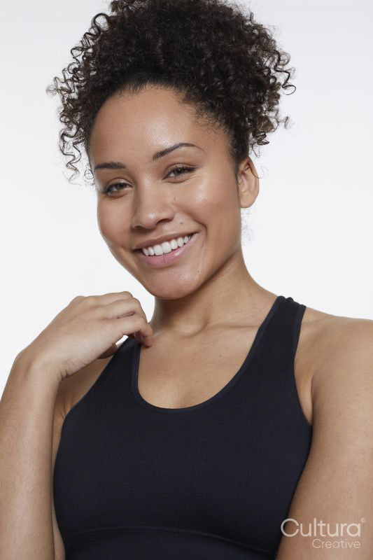 Studio portrait of smiling athletic woman in black top