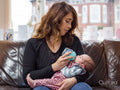 Mother bottle feeding infant daughter