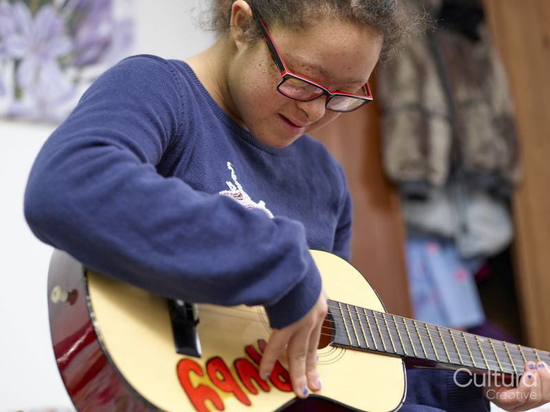 Girl with Down syndrome playing ukulele