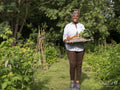 Portrait of mature woman holding vegetables from garden