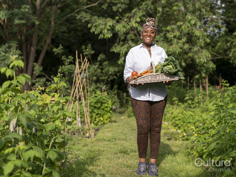 Portrait of mature woman holding vegetables from garden