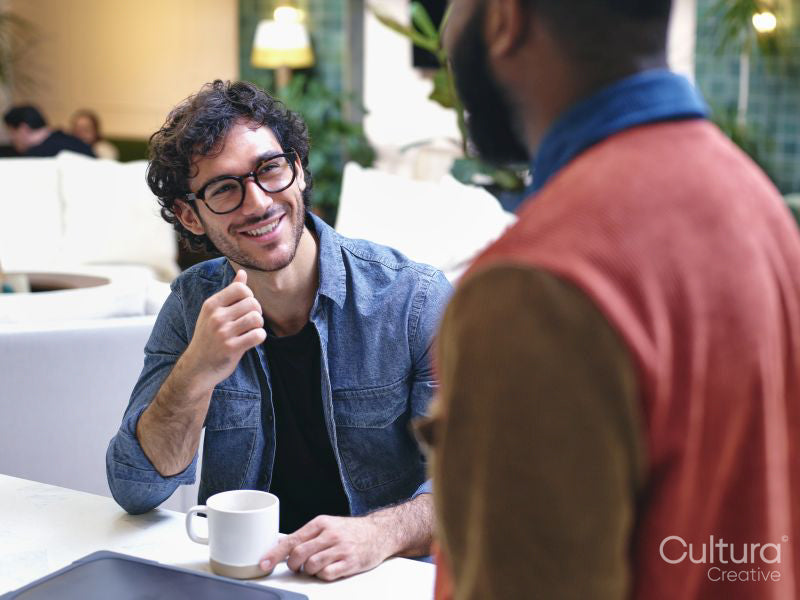 Two smiling men talking in creative studio