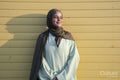 Portrait of young Muslim woman looking away against yellow wall