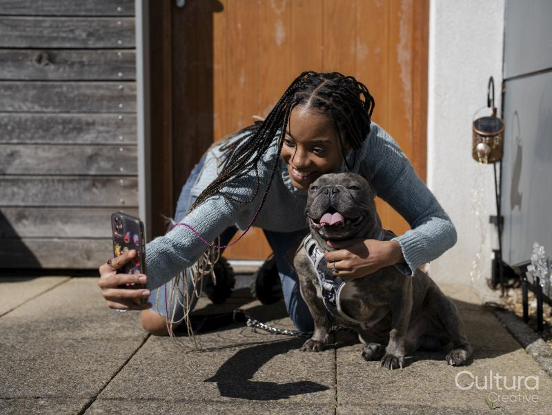 Woman taking selfie with dog on sunny day