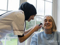 Doctor using otoscope and examining patients ear