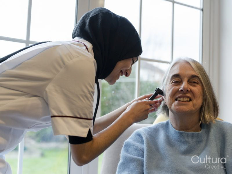 Doctor using otoscope and examining patients ear