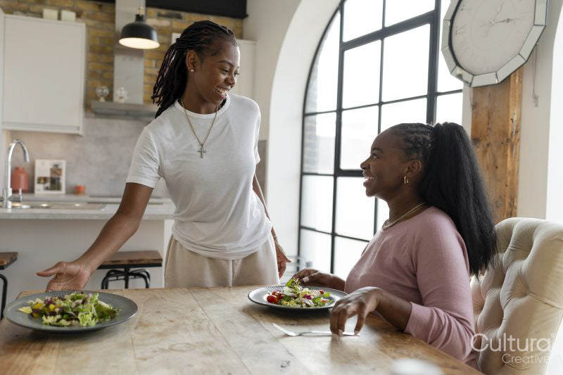 Smiling woman serving dinner for girlfriend at home