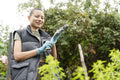 Portrait of woman putting on glove in urban vegetable garden