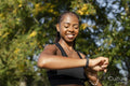Smiling young woman checking time after jogging