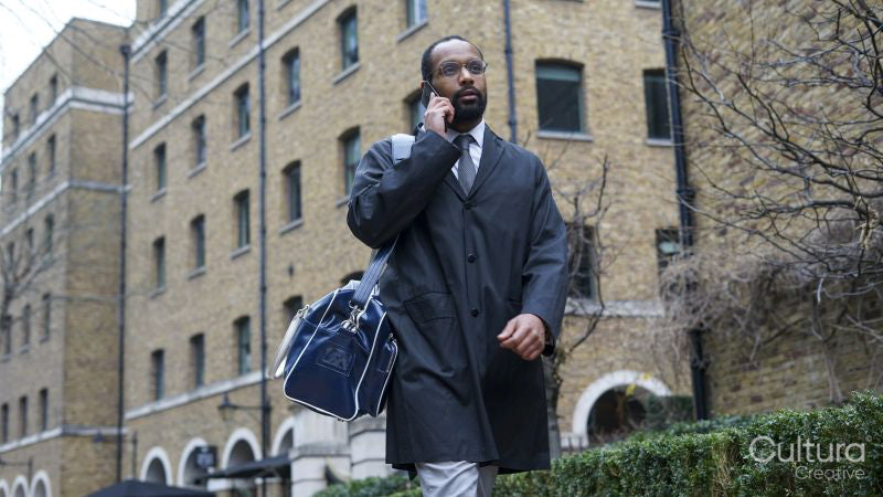 Business man walking and using phone