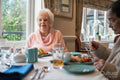 Two senior ladies dining at cafeteria in nursing home