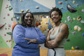 Portrait of mother and daughter standing in front of climbing wall