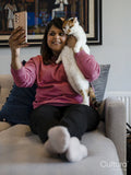 Woman taking selfie with cat on sofa