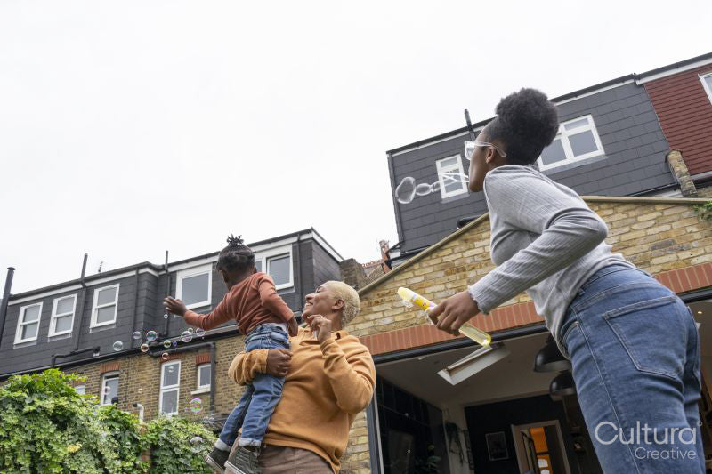 Mother and daughters playing with soap bubbles