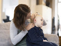 Mother helping daughter with hearing aid