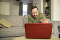 Man sitting on sofa and using laptop