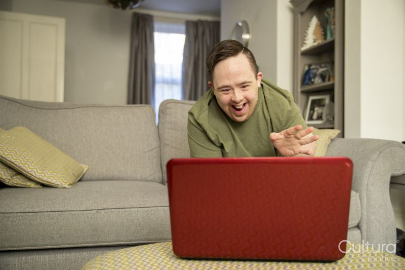 Man sitting on sofa and using laptop