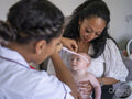 Nurse taking growth measurements of baby girl