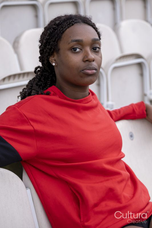 Portrait of athletic woman sitting on chair at empty stadium